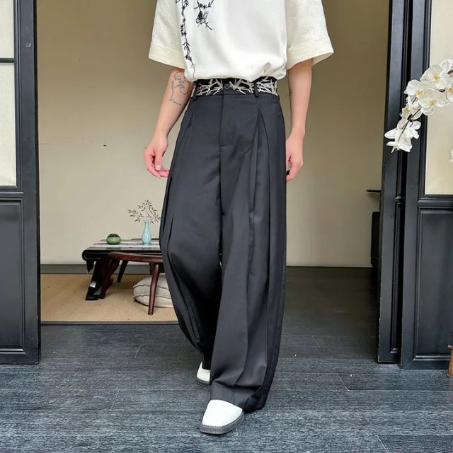 Man wearing black hakama-style wide-leg pants with white graphic tee and sneakers — Japanese urban fashion outfit