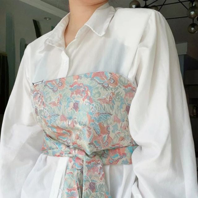 Wide kimono belt with soft floral pattern tied at the waist