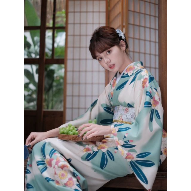 Floral kimono with teal and pink flower pattern worn in a traditional setting