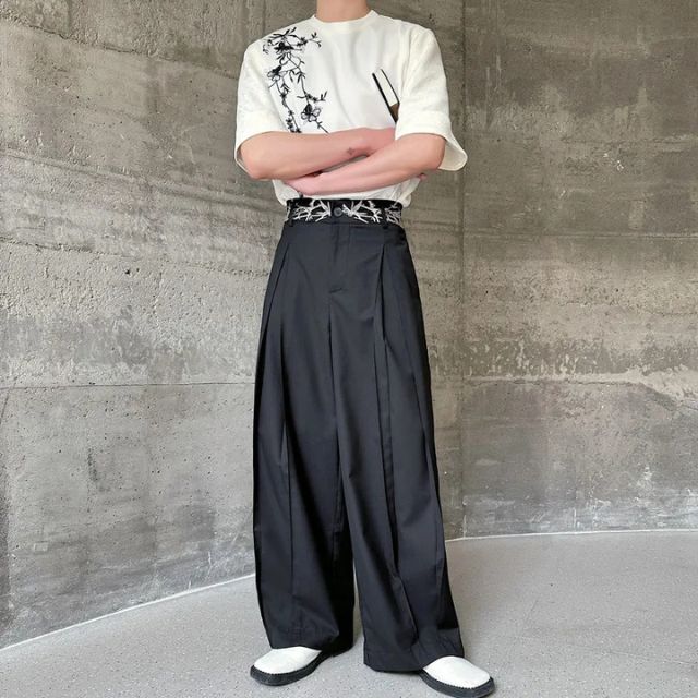 Man wearing black hakama-style wide-leg pants with white graphic tee and sneakers — Japanese urban fashion outfit