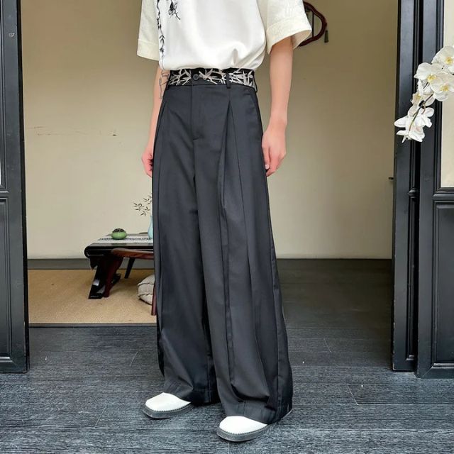 Man wearing black hakama-style wide-leg pants with white graphic tee and sneakers — Japanese urban fashion outfit