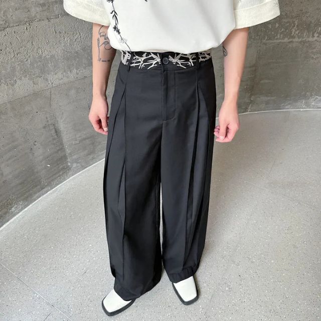 Man wearing black hakama-style wide-leg pants with white graphic tee and sneakers — Japanese urban fashion outfit