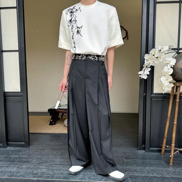 Man wearing black hakama-style wide-leg pants with white graphic tee and sneakers — Japanese urban fashion outfit