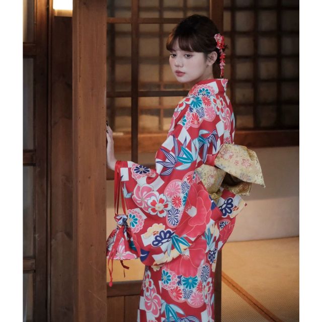 Elegant red kimono with white floral design styled in a traditional setting