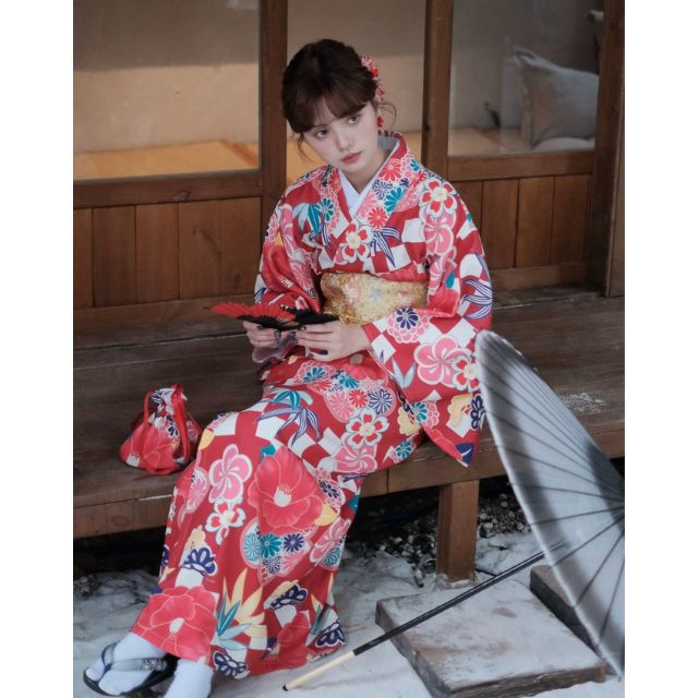 Elegant red kimono with white floral design styled in a traditional setting