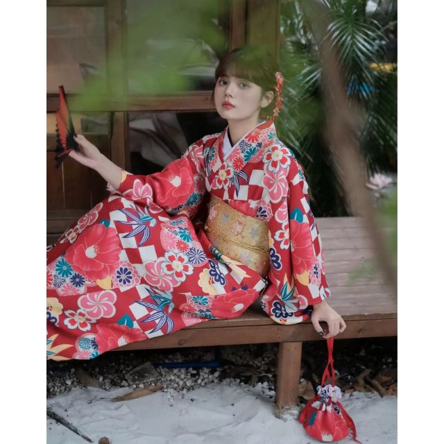 Elegant red kimono with white floral design styled in a traditional setting