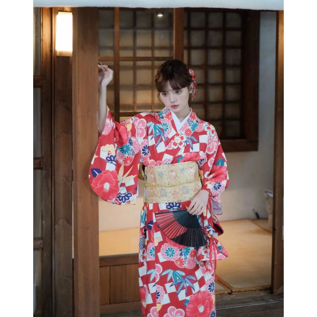 Elegant red kimono with white floral design styled in a traditional setting