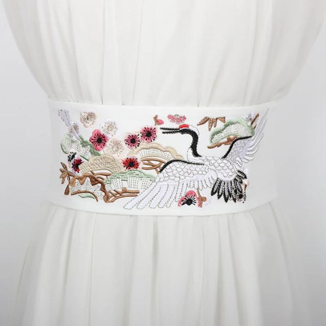 Embroidered kimono sash belt with crane design tied around waist