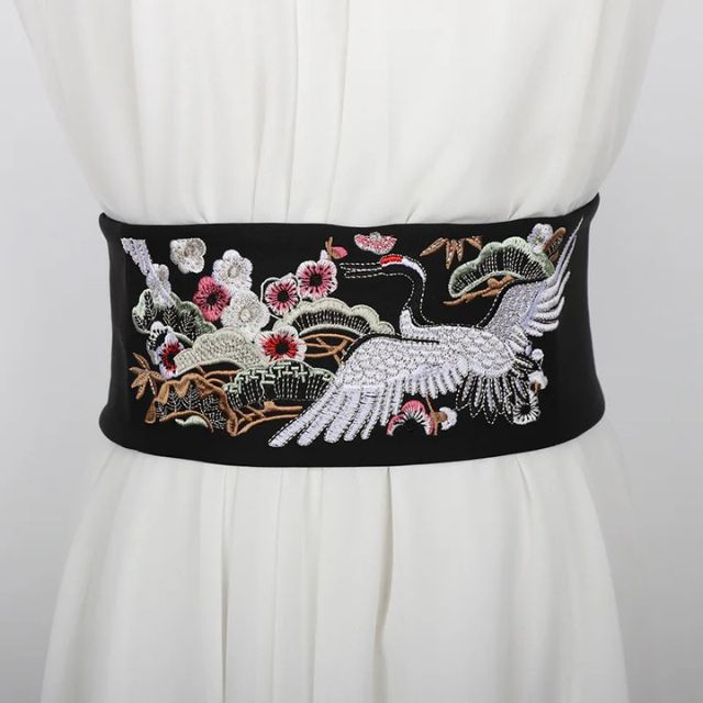 Embroidered kimono sash belt with crane design tied around waist