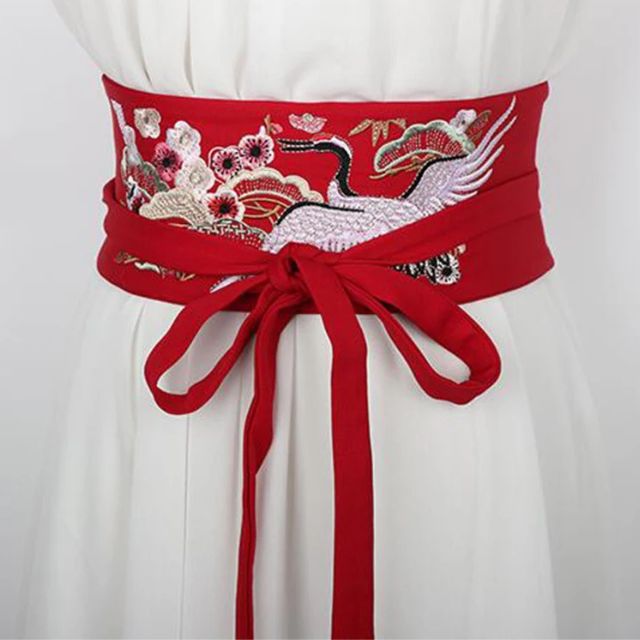 Embroidered kimono sash belt with crane design tied around waist
