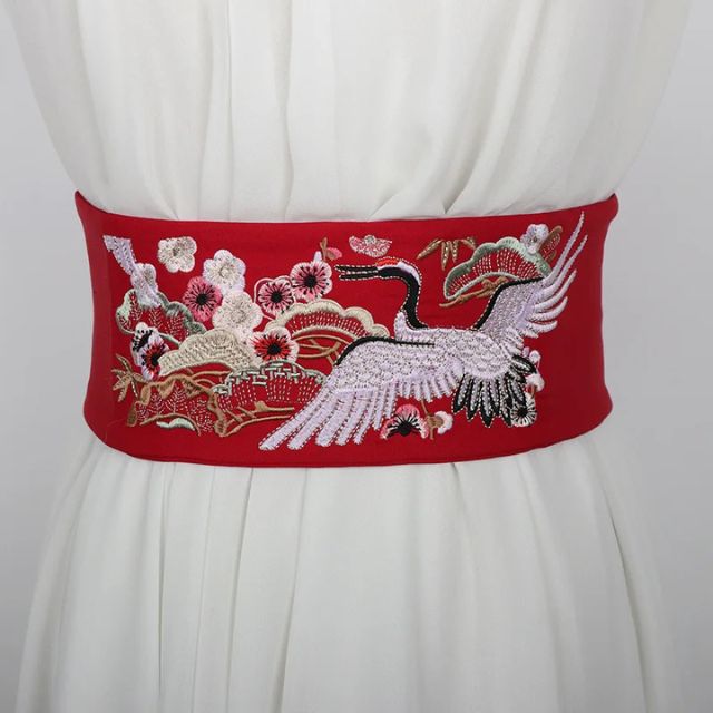 Embroidered kimono sash belt with crane design tied around waist