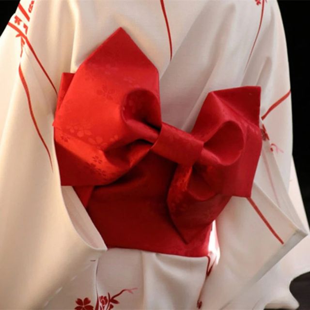 Red obi sash tied in decorative bow over white floral kimono — Japanese jacquard polyester belt